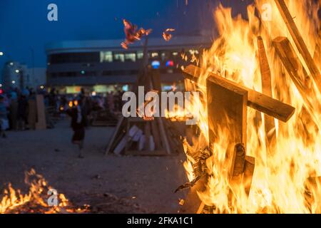 Un fuoco brucia durante la festa ebraica di Lag Ba'Omer, che si svolge ogni 18 del mese ebraico Iyar. È consuetudine durante questa vacanza fare incendi. Quest'anno, a causa del pericolo di incendio, tutti gli incendi sono stati concentrati in pochi siti, da cui il gran numero di piri. Foto Stock