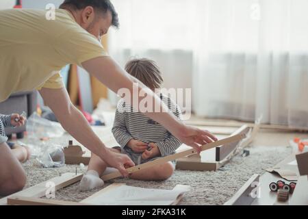 Processo di assemblaggio di mobili per la casa, tavolo di assemblaggio di padre e bambini Foto Stock