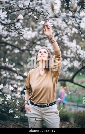 bella ragazza nel parco con magnolie Foto Stock