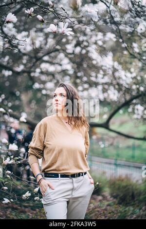 bella ragazza nel parco con magnolie Foto Stock