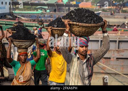 Uomini e donne che lavorano sodo per guadagnare soldi. Caricano carbone dalla barca ho catturato questa immagine il 17-11-2018 da Amen Bazar, Dhaka, Bangladesh Foto Stock