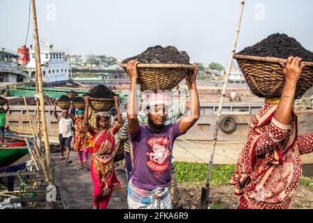 Uomini e donne che lavorano sodo per guadagnare soldi. Caricano carbone dalla barca ho catturato questa immagine il 17-11-2018 da Amen Bazar, Dhaka, Bangladesh Foto Stock