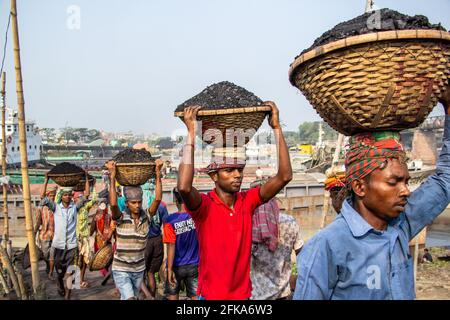 Uomini e donne che lavorano sodo per guadagnare soldi. Caricano carbone dalla barca ho catturato questa immagine il 17-11-2018 da Amen Bazar, Dhaka, Bangladesh Foto Stock