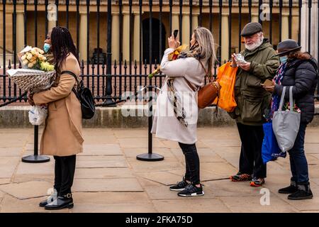 Gli inglesi aspettano di rendere omaggio al principe Filippo (il duca di Edimburgo) ponendo fiori alle porte di Buckingham Palace, Londra, Regno Unito. Foto Stock