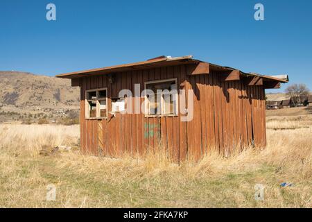 Una baracca abbandonata si trova in un pascolo asciutto in una giornata di sole a Klamath Falls, Oregon. Foto Stock