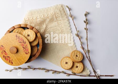 su un tovagliolo su uno sfondo bianco willow ramoscelli e. una tazza con biscotti rotondi Foto Stock