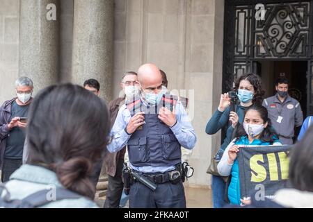 Barcellona, Spagna. 29 Apr 2021. Un poliziotto che guarda un protestante durante la manifestazione.in previsione delle manifestazioni del 1° maggio, la giornata internazionale dei lavoratori, l'Unione indipendente di lavoratori domestici e di assistenza, ha indetto una manifestazione di fronte all'edificio dell'Istituto Nazionale per la promozione del lavoro di Barcellona, per richiedere documenti per tutti i lavoratori domestici. (Foto di Thiago Prudencio/SOPA Images/Sipa USA) Credit: Sipa USA/Alamy Live News Foto Stock