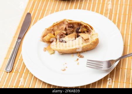 Piatto bianco con un pezzo di strudel su un tavolo. Foto Stock