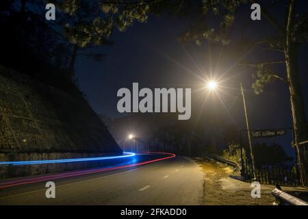La vista notturna della strada di passaggio è scritta in Vietnamita "nebbia" con magici semafori e traffico sentieri che rendono la notte più bella Foto Stock