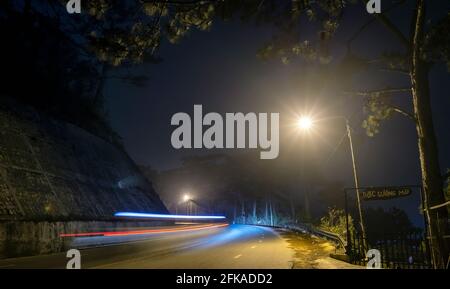 La vista notturna della strada di passaggio è scritta in Vietnamita "nebbia" con magici semafori e traffico sentieri che rendono la notte più bella Foto Stock