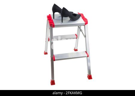 Paio di scarpe eleganti nere appuntate con tacco alto da donna su scala in metallo a due lati larghi, isolate su sfondo bianco. Ideale Foto Stock