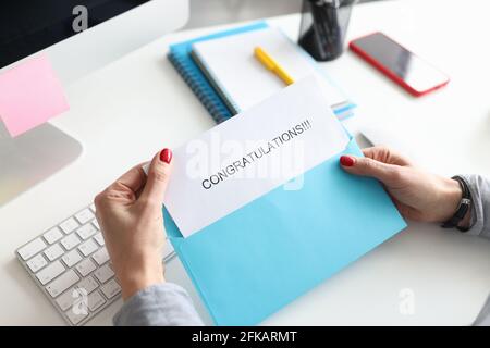 Le mani femminili tengono la busta con closeup di congratulazioni Foto Stock