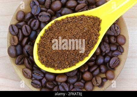 Un cucchiaio di caffè appena macinato su chicchi di caffè Foto Stock