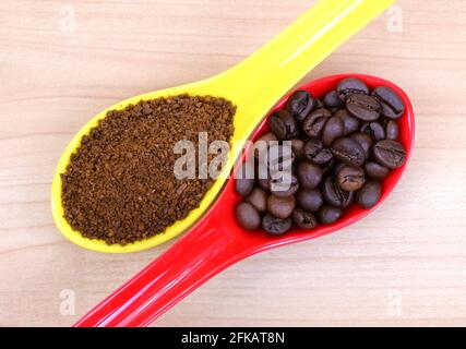 Un cucchiaio di caffè appena macinato e chicchi di caffè Foto Stock