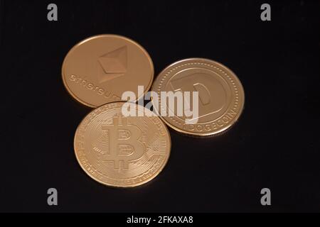 Tre monete d'oro criptato, Bitcoin, Ethereum, Dogecoin, BTC ETH DOGE, criptovaluta fisica, contrattazioni di monete criptovalute Foto Stock