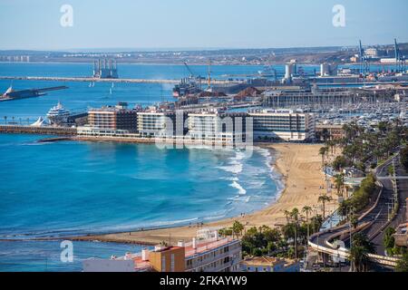 Alicante, Spagna. 21 novembre 2020. Famosa spiaggia Postiquet ad Alicante quasi vuota in una giornata di sole. Sullo sfondo un hotel Melia e l'arbo della città Foto Stock