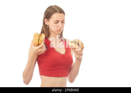 donna giovane seria con hamburger su sfondo bianco isolato Foto Stock