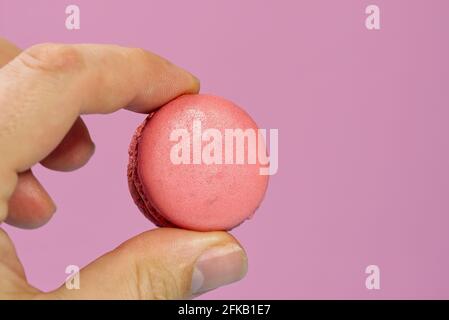 Macaron da dessert francese su sfondo rosa. Macarons moderni su sfondo colorato. Foto Stock