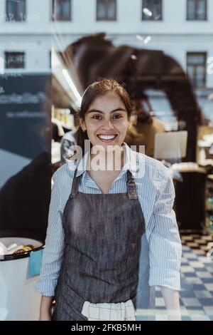 Ritratto di una donna sorridente al negozio di gastronomia Foto Stock