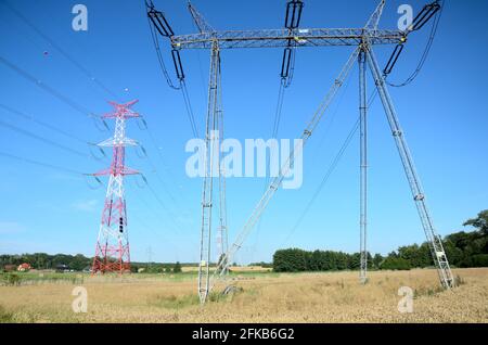 Paesaggio rurale con alti poli elettrici in bassa Slesia, Polonia. Bella estate con cielo blu. Foto Stock
