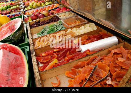 caramelle e frutta fresca in uno stand mercato Foto Stock