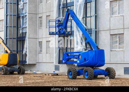 Bielorussia, Minsk - 28 maggio 2020: Veicolo industriale con piattaforma di sollevamento sullo sfondo di un nuovo edificio moderno in costruzione presso una costr Foto Stock