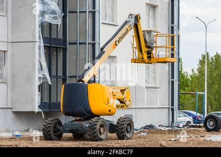 Bielorussia, Minsk - 28 maggio 2020: Veicolo industriale con piattaforma di sollevamento sullo sfondo di un nuovo edificio moderno in costruzione presso una costr Foto Stock