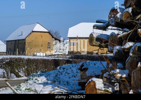 Legno Stack sfocato in primo piano e due vecchie case in backgroound a fuoco Foto Stock