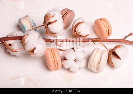 Composizione elegante, macaron al cioccolato assortiti francesi, tazza da caffè, taccuino, bol di cotone, tavolo con intonaco bianco. Buon compleanno mothe Foto Stock