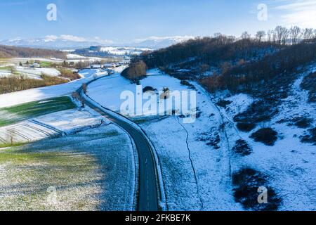 Vista panoramica di un'autostrada che porta verso la catena montuosa delle alpi in francia presa con un drone. Foto Stock