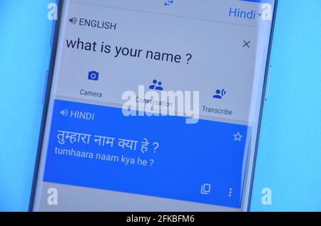 Mandi, Himachal Pradesh, India - 03 05 2021: Tradurre 'Qual è il tuo nome' Inglese in lingua hindi su Google Traduci visualizzazione su cellulare isolato su sfondo blu. Foto Stock