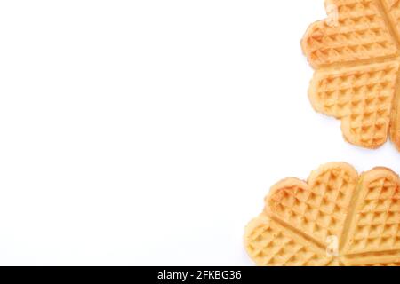 Semplici waffle belgi fatti in casa appena sfornati a forma di cuore isolati su sfondo bianco. Dolci europei da forno. Spazio di copia, primo piano, vista dall'alto, Foto Stock