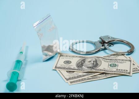 Un sacco di droghe, in dollari US e manette sul tavolo. Concetto - La punizione per il possesso di stupefacenti. Copia spase, spase per il testo. Foto Stock