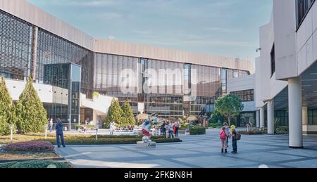 Sochi, Russia - 8 marzo 2020: Il cortile dell'aeroporto della città di Sochi. I passeggeri attendono il loro volo all'aperto tra le piante vicine Foto Stock