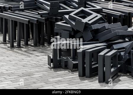 Pila di nuove strutture metalliche o di materiale industriale in acciaio su marciapiede delle lastre di pavimentazione in cantiere. Foto Stock