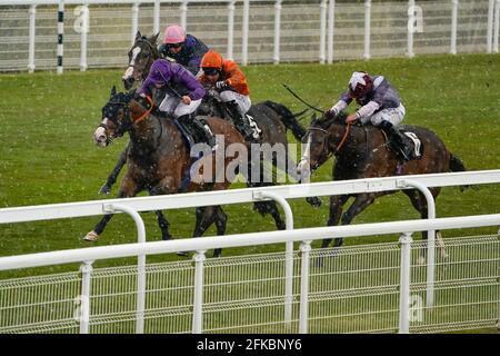 Thomas Greatrex a cavallo del ragazzo di Atalanta (a sinistra, viola) che viene a casa per vincere il Veuve Clicquot handicap come la neve cade durante la corsa all'ippodromo di Goodwood a Chichester. Data immagine: Venerdì 30 aprile 2021. Foto Stock