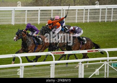 Thomas Greatrex a cavallo del ragazzo di Atalanta (a sinistra, viola) che viene a casa per vincere il Veuve Clicquot handicap come la neve cade durante la corsa all'ippodromo di Goodwood a Chichester. Data immagine: Venerdì 30 aprile 2021. Foto Stock