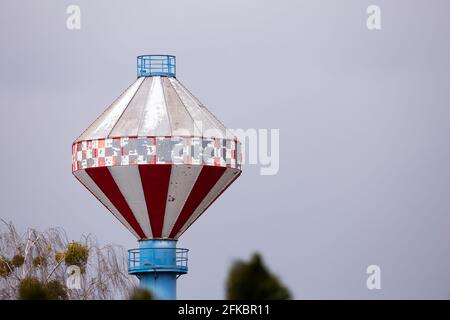 Insolito camino di un impianto di riscaldamento comunale con una camera in cima. Fatto in un giorno nuvoloso. Luce soffusa. Foto Stock