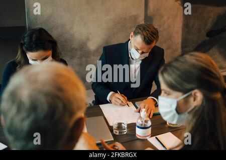 Gli uomini d'affari discutono di documenti durante la riunione nella sala riunioni in ufficio Foto Stock