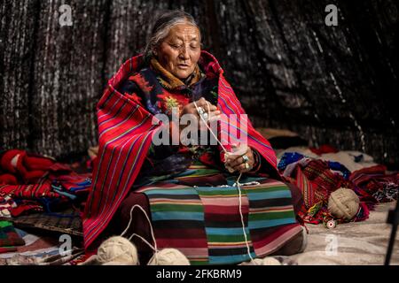 (210430) -- LHASA, 30 aprile 2021 (Xinhua) -- Tseten Lhamo tesse a casa a Dongmar, nella contea di Rutog, nella prefettura di Ngari, nella regione autonoma del Tibet della Cina sud-occidentale, 27 aprile 2021. Tseten Lhamo, nato nel 1945, lavorò come serf prima della riforma democratica in Tibet nel 1959, che abolì il suo feudale sotto la teocrazia. 'La vita dei nostri servi è amara delle erbe amare', Tseten Lhamo ha ricordato la sua vita in passato. Dopo la riforma democratica, si sono avvenuti cambiamenti positivi. Tseten Lhamo ora vive in una grande casa con yaks e capre. (Foto di Konchog Chosphel/Xinhua) Foto Stock