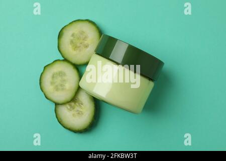 Vasetto con gel cosmetico e fettine di cetriolo su sfondo di menta Foto Stock