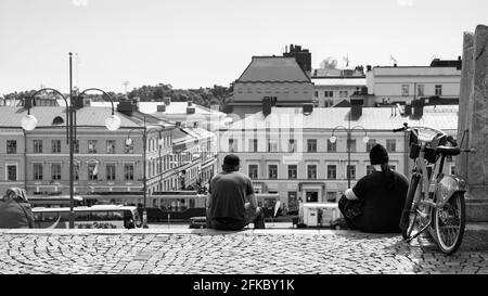 Helsinki, Finlandia - 26 luglio 2017: Piazza del Senato a Helsinki e persone che riposano sulle scale. Fotografia in bianco e nero Foto Stock