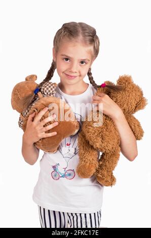 Bambina che tiene un orsacchiotto. Isolato su sfondo bianco. Ragazza abbracciando due teddyBears. Bambino felice. Foto Stock