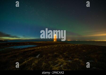 Faro sulla penisola di Reykjanes nortern sotto le luci. L'Islanda. Il timelapse Foto Stock