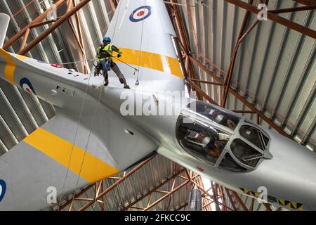 Cosford, Regno Unito, 30 aprile 2021. Il RAF Museum Cosford's National Cold War Exhibition Hangar presenta un certo numero di aerei sospesi e grandi, alcuni dei quali sono oltre 100 piedi in aria. Con un accesso limitato o difficoltoso per il personale del museo, una pulizia annuale degli aeromobili più grandi e sospesi, insieme all'ispezione dei cavi di sospensione, viene eseguita da un team specializzato utilizzando una combinazione di accesso tramite fune e piattaforme meccaniche. Credit: Paul Bunch/Alamy Live News Foto Stock