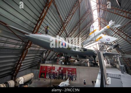 Cosford, Regno Unito, 30 aprile 2021. Il RAF Museum Cosford's National Cold War Exhibition Hangar presenta un certo numero di aerei sospesi e grandi, alcuni dei quali sono oltre 100 piedi in aria. Con un accesso limitato o difficoltoso per il personale del museo, una pulizia annuale degli aeromobili più grandi e sospesi, insieme all'ispezione dei cavi di sospensione, viene eseguita da un team specializzato utilizzando una combinazione di accesso tramite fune e piattaforme meccaniche. Credit: Paul Bunch/Alamy Live News Foto Stock