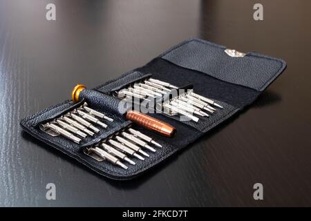 Un set di cacciaviti in una custodia in pelle su legno primo piano del tavolo Foto Stock