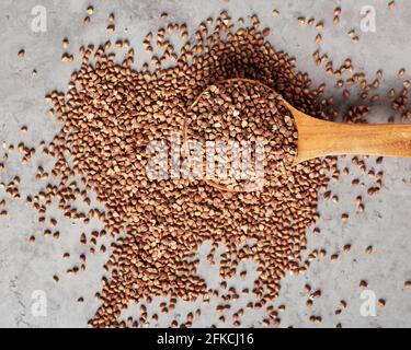 Grano saraceno grezzo in un cucchiaio di legno. Grani interi organici. Foto Stock