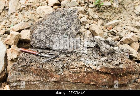 Geologi martello su fosohorite - Geological Fieldwork. Geologo martello, martello da roccia, picchiatore da roccia, o geologico picchietto - martello utilizzato per la spaccatura Foto Stock