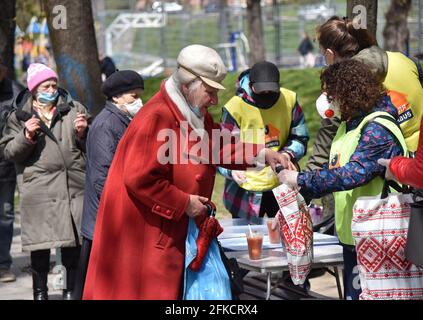 Lviv, Ucraina. 29 Apr 2021. Una donna riceve un borsch libero e un pacchetto pasquale dalla Comunità di Soccorso di Emmaus. Alla vigilia della Pasqua ortodossa, che sarà celebrata il 2 maggio, la comunità di mutuo soccorso di Emmaus a Lviv ha distribuito pacchetti pasquali ai senzatetto e alle persone a basso reddito. (Foto di Pavlo Palamarchuk/SOPA Images/Sipa USA) Credit: Sipa USA/Alamy Live News Foto Stock